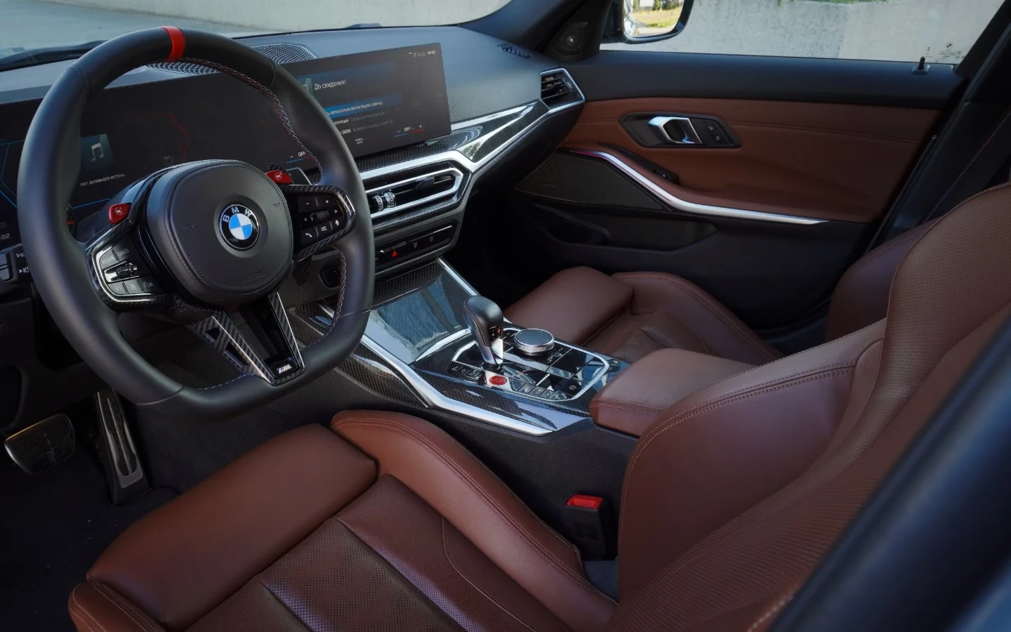 Interiér BMW M3 Competition s hnědými koženými sedadly a sportovním volantem