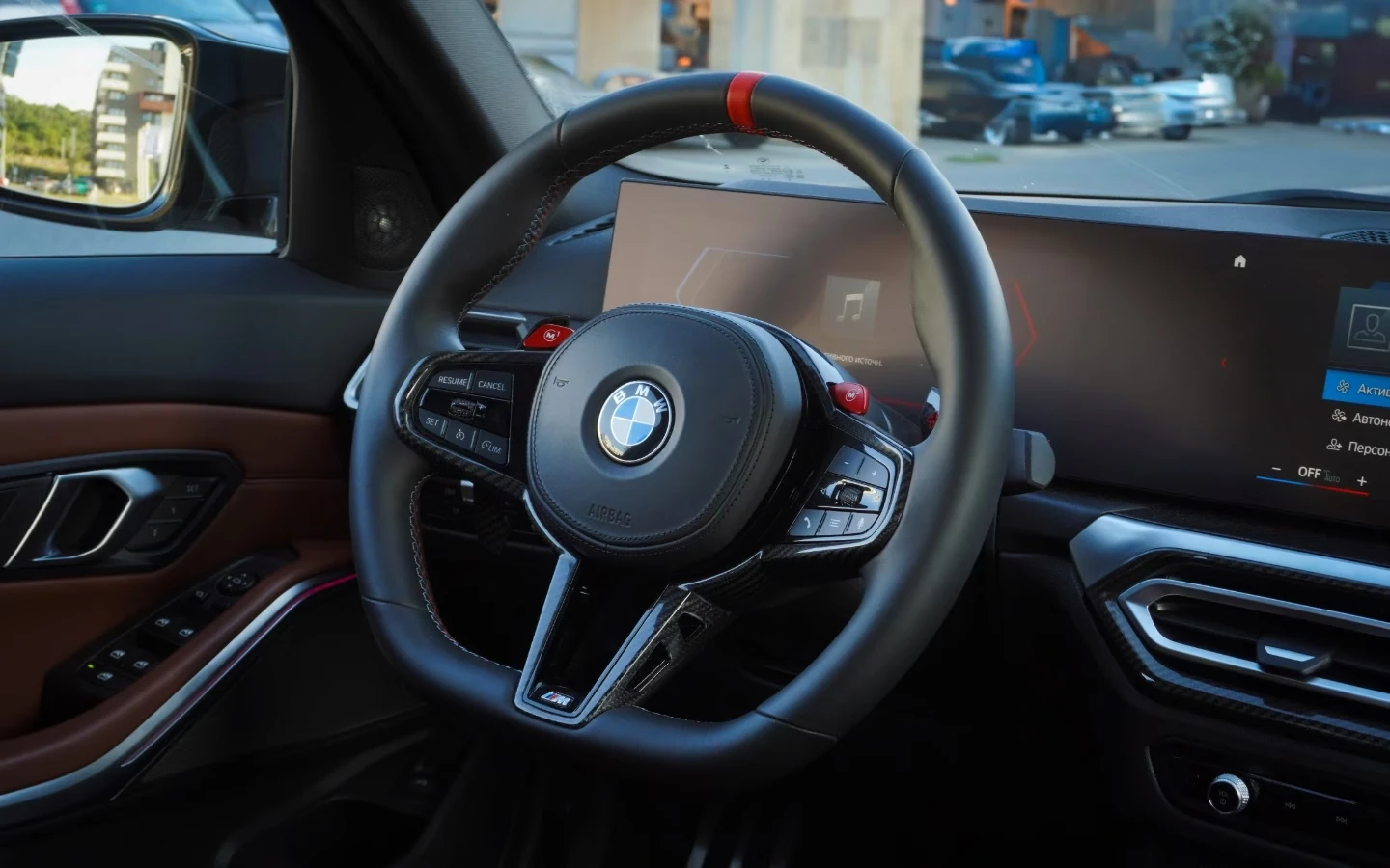 Detail sportovního volantu BMW M3 Competition s karbonovými prvky a digitálním displejem