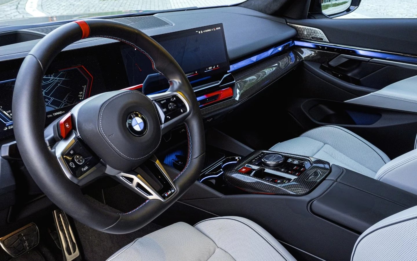 Interiér BMW M5 – sportovní volant, digitální přístrojový panel a bílá kožená sedadla